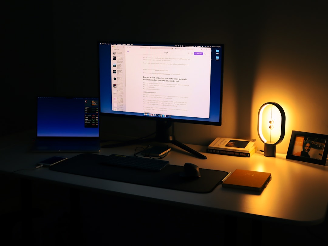 A clean, modern office desk featuring a person interacting with a futuristic transparent screen, representing the future of digital marketing work.