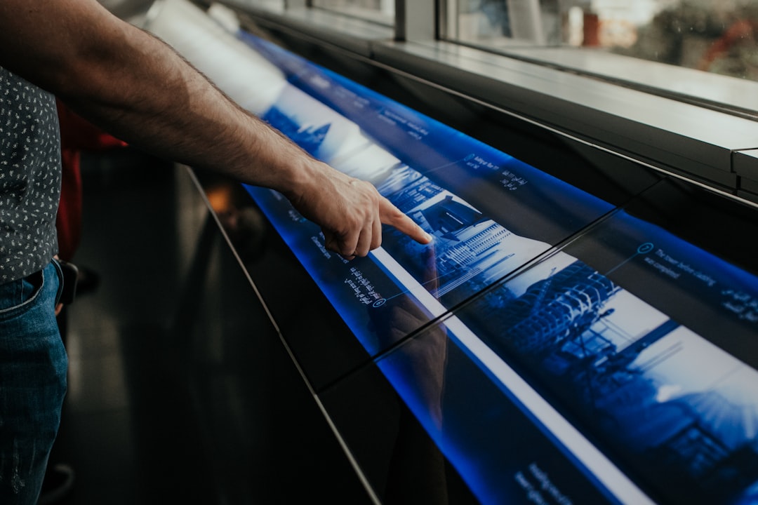 A person in a modern setting touches a large interactive screen displaying a minimalist data visualization, signifying clarity in future marketing analytics.