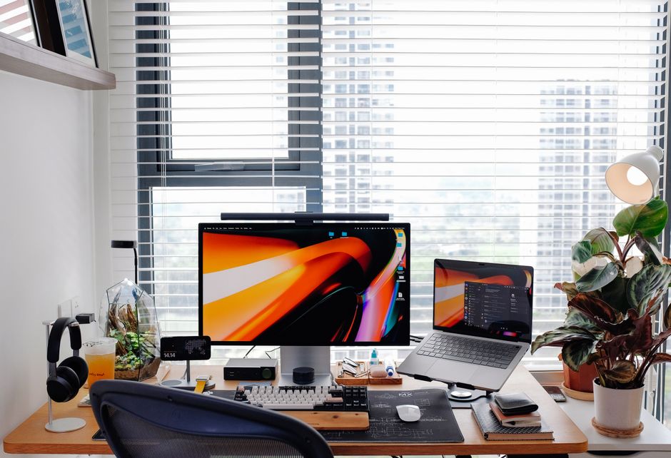 A clean, minimalist office desk with a laptop and notebook set against a large window with a view of a sprawling city, representing strategic planning for the future of real estate marketing.